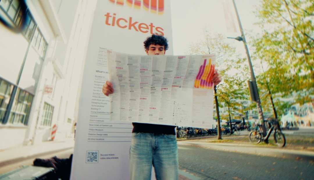Bezoeker leest een grote plattegrond voor de DDW-ticketzuil